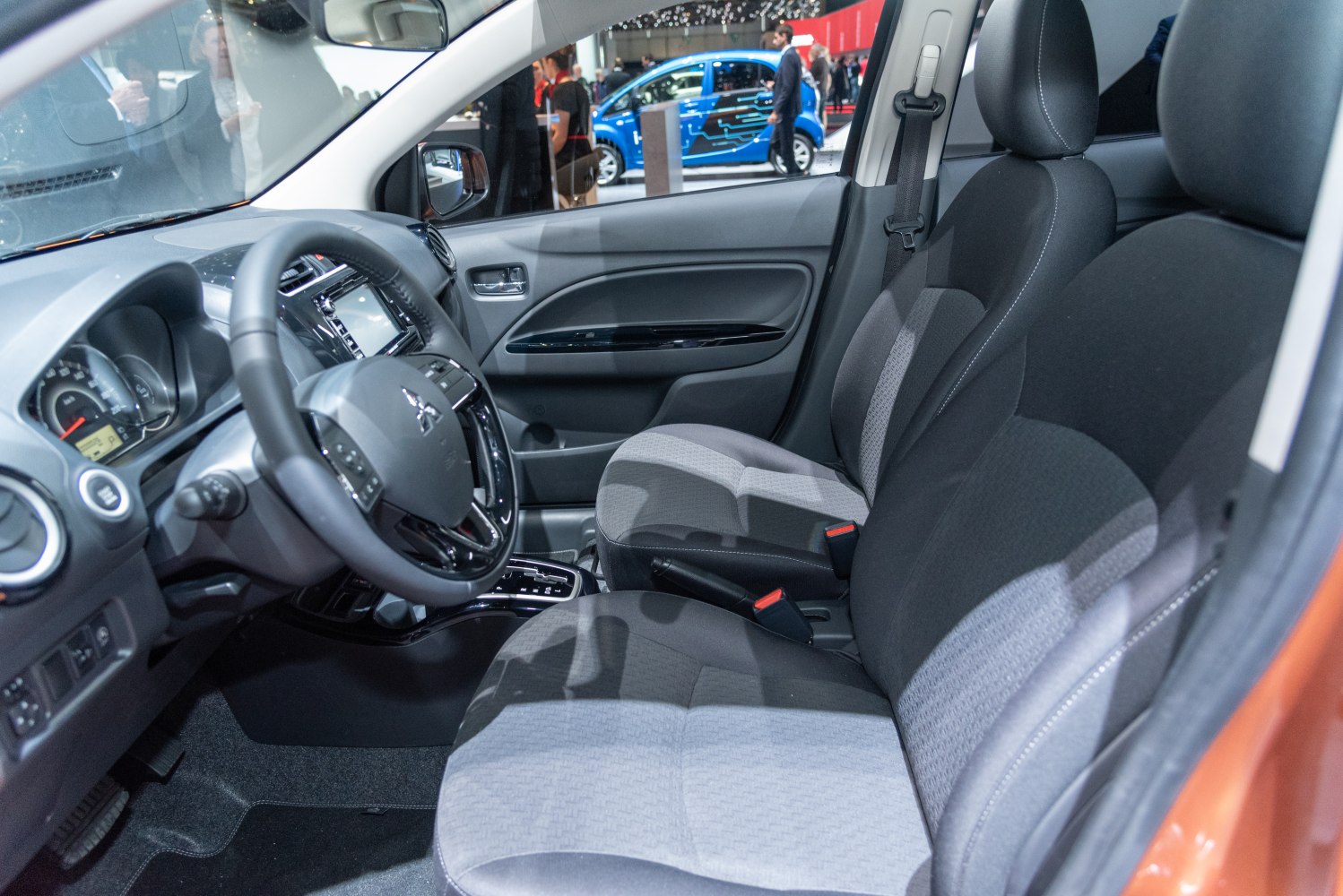 Front interior cabin with fabric seats and dashboard.