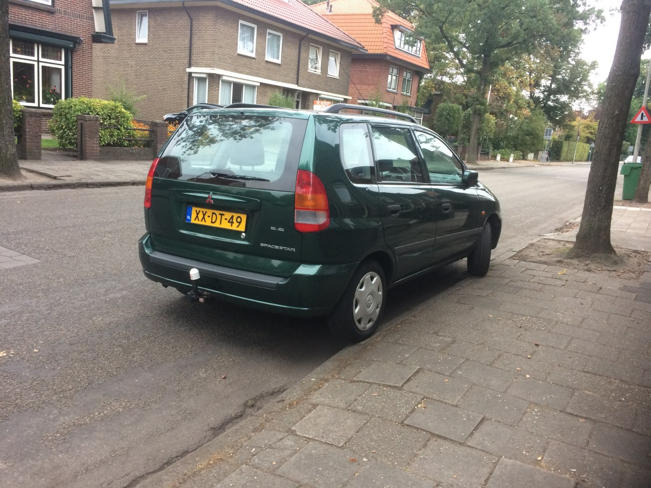 Compact hatchback rear-side view with tow hitch parked on street