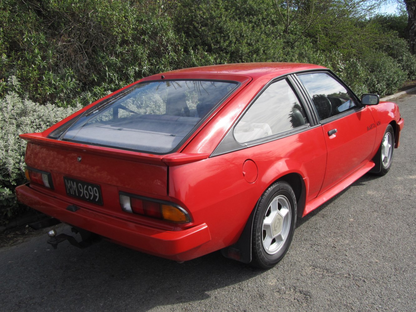 Rear side view of a hatchback with a sporty spoiler and sloped rear window