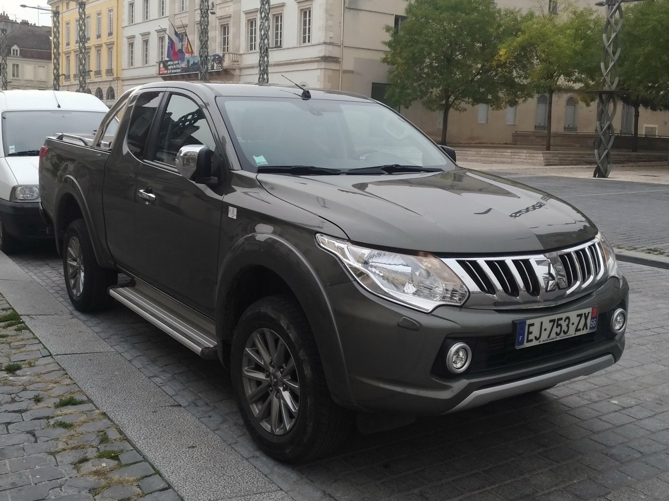 Front and side view of a pickup with chrome mirrors and alloy wheels