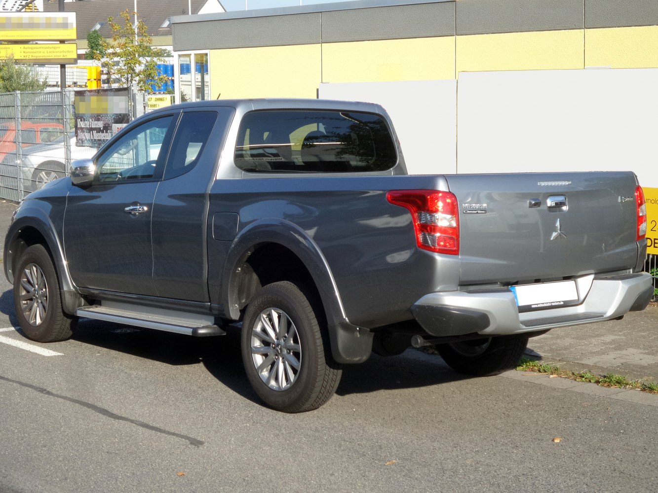 Rear side view of extended cab pickup with cargo bed