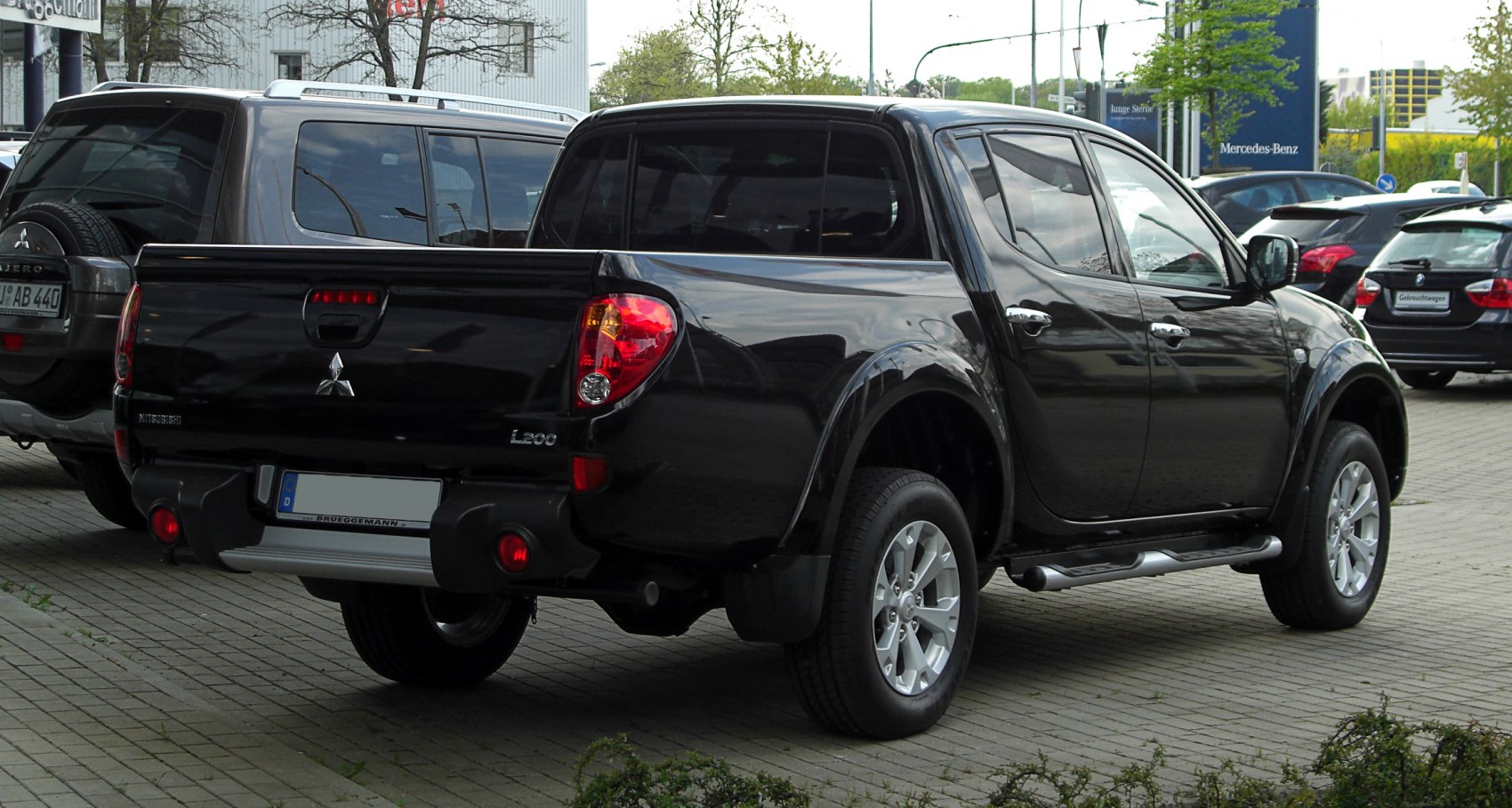 Rear and side view of black pickup truck with double cab and alloy wheels