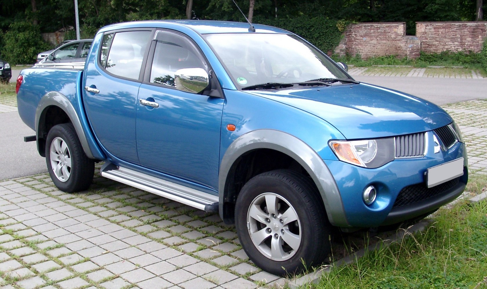 Front side view of double cab pickup with alloy wheels and running boards