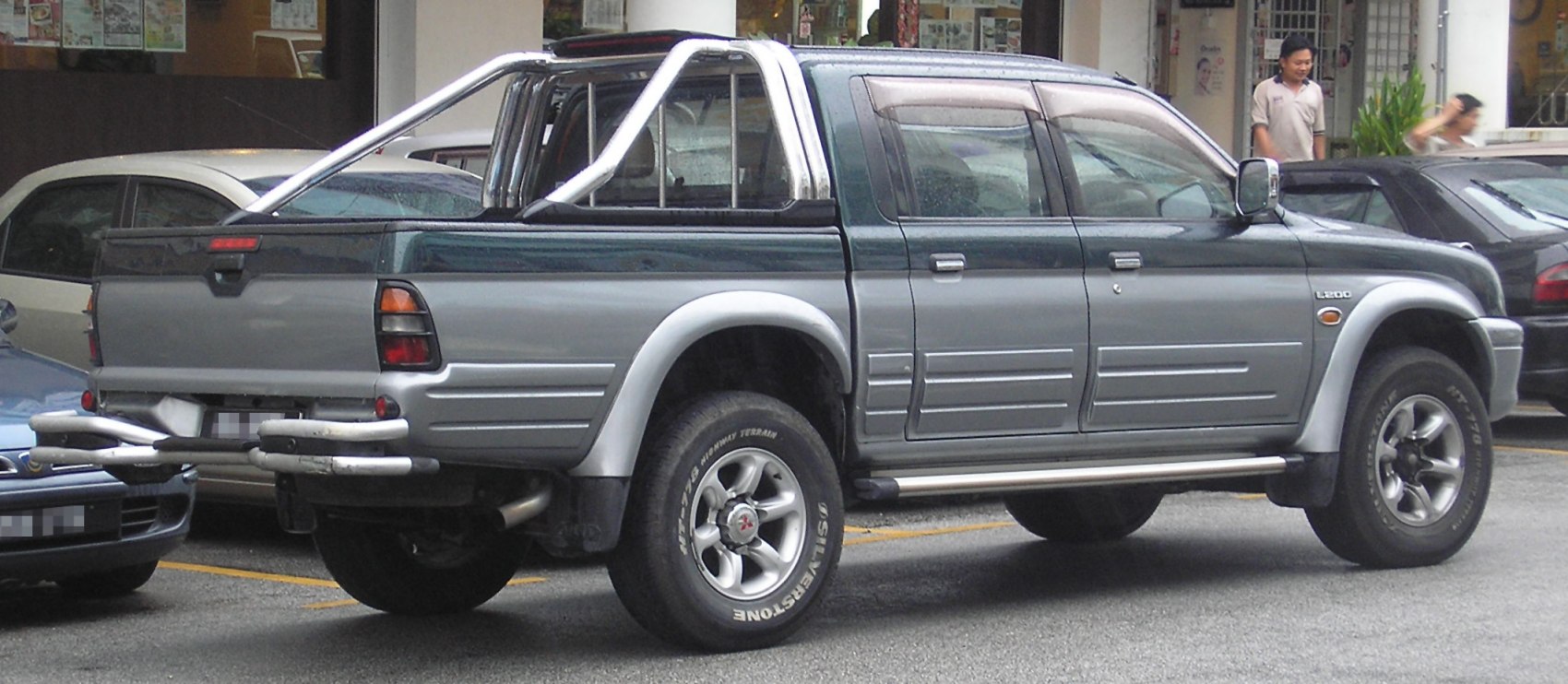 Pickup truck double cab rear-side view with roll bars and alloy wheels