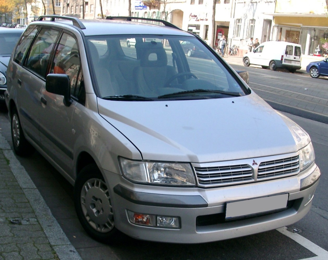 Front angled view of a modern station wagon with roof rails and distinctive grille