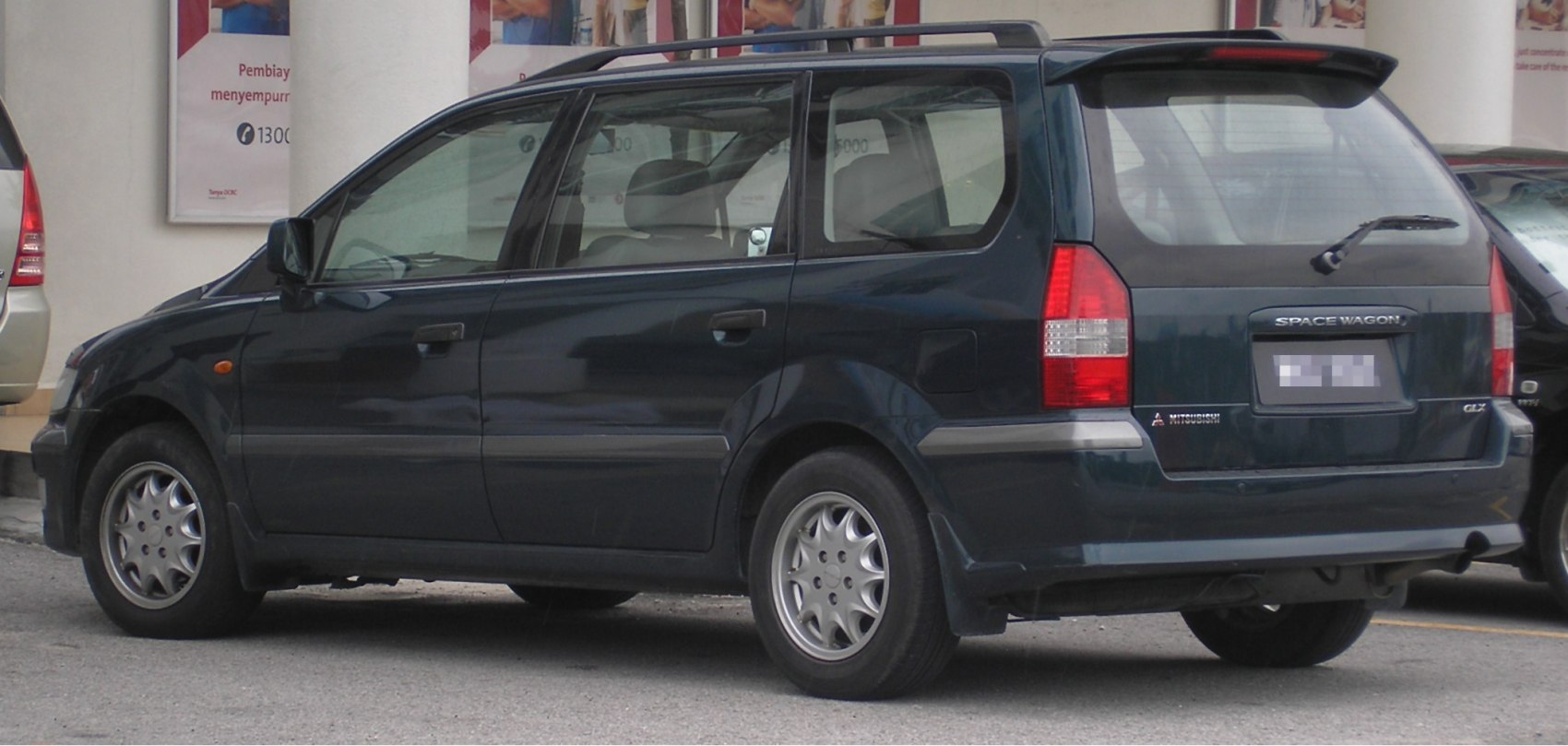 Rear side view of a station wagon with rear spoiler and roof rails