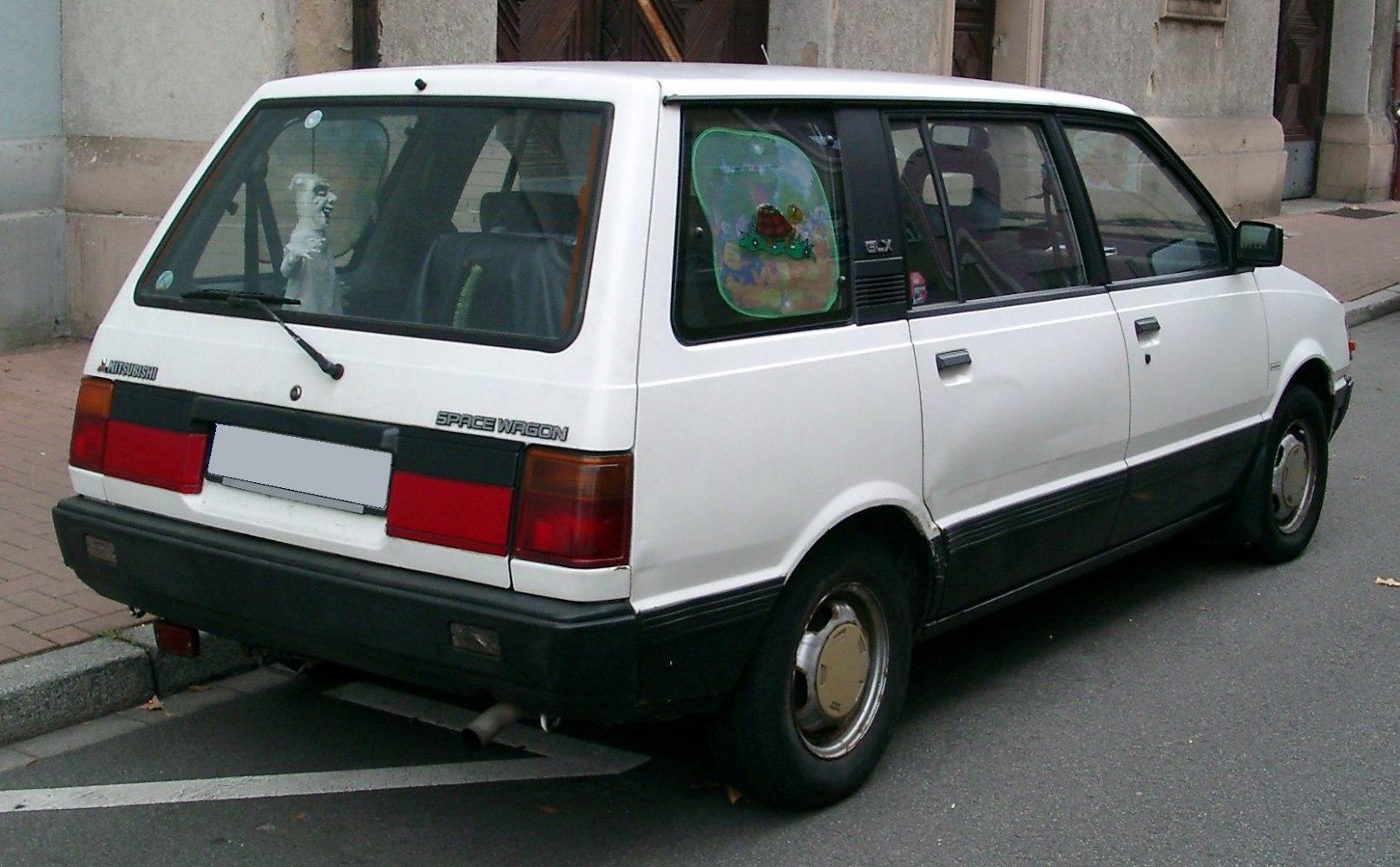Rear and side view of vintage MPV with boxy design and large windows