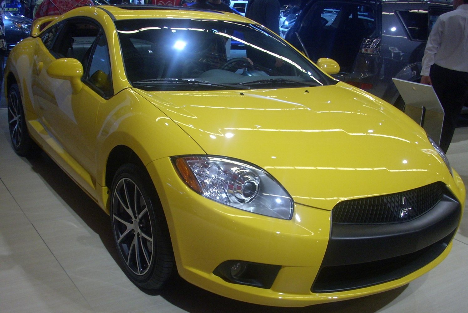Sporty yellow coupe front end with headlights and grille