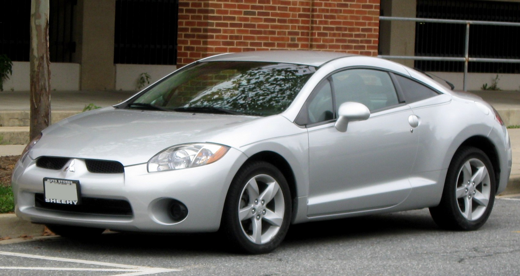 Silver two-door coupe with rounded headlights and five-spoke alloy wheels