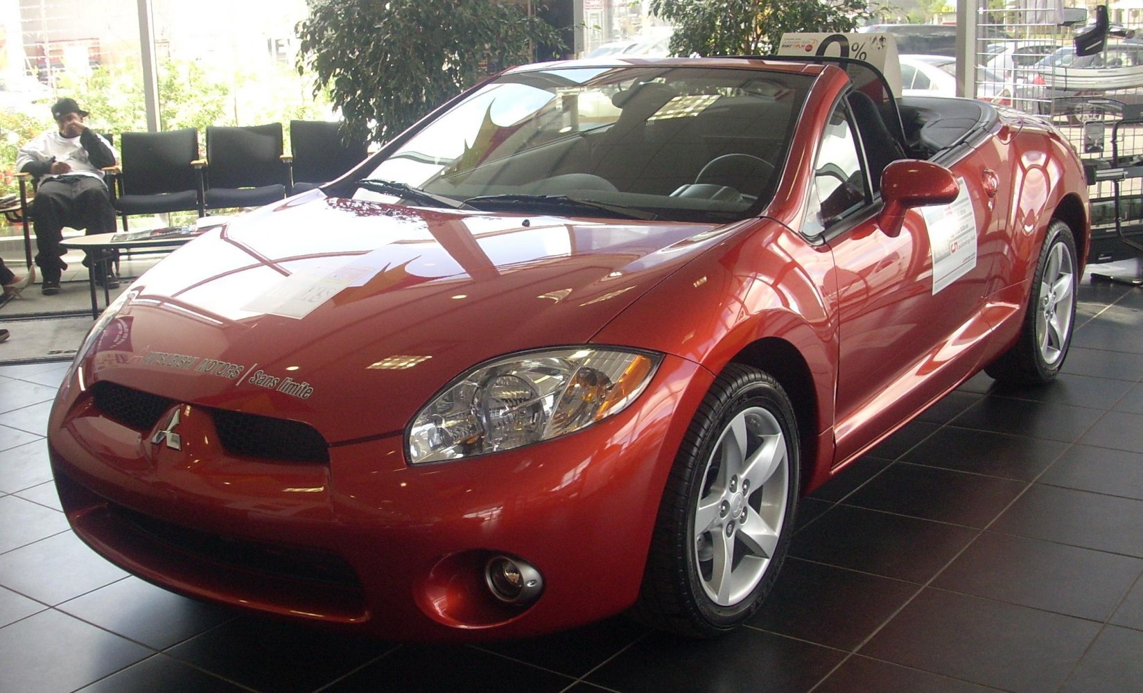 Front side view of a convertible sports coupe with sharp headlights and alloy wheels