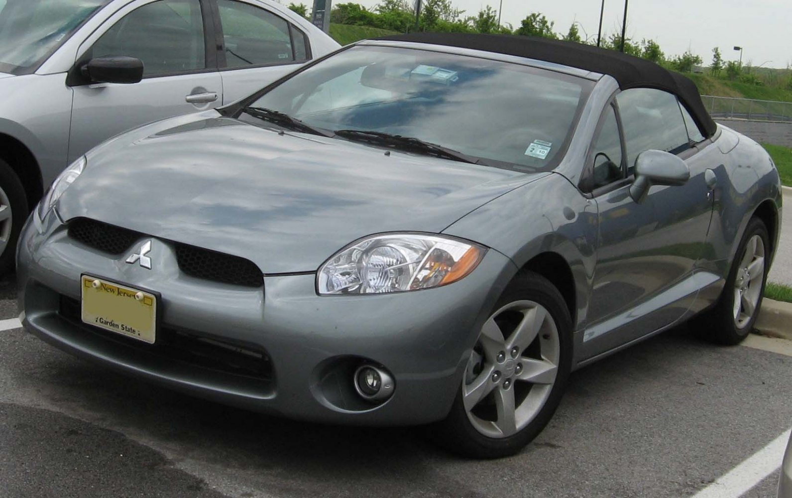 Convertible sportcar with soft-top roof, front and side view