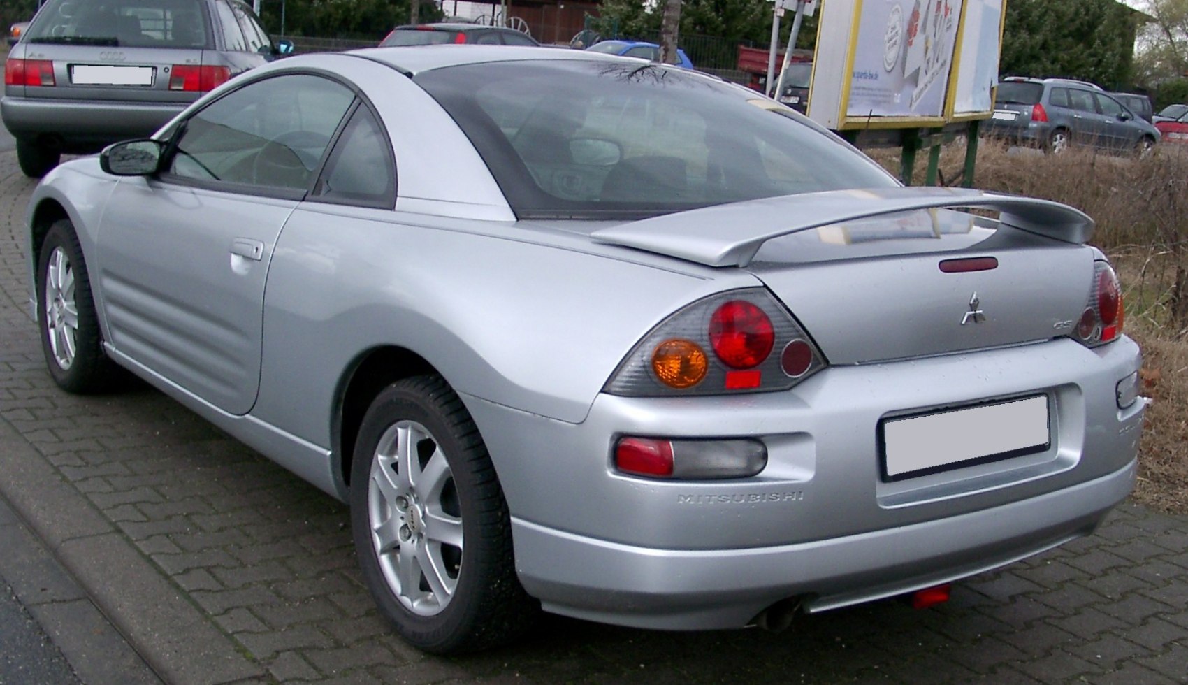 Silver coupe rear side with spoiler and distinct tail lights