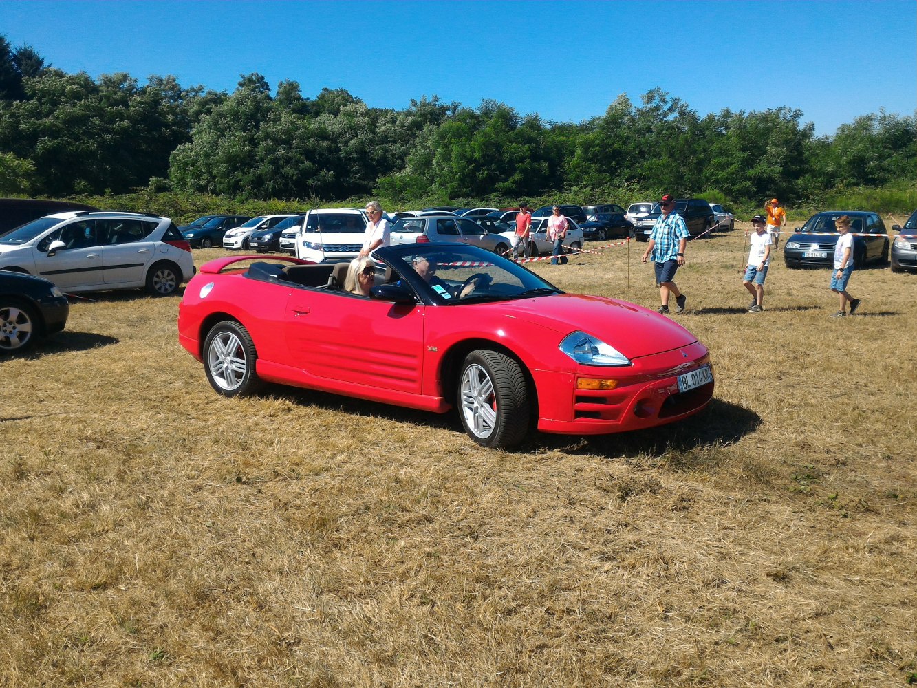 Red convertible sports car with open roof and alloy wheels
