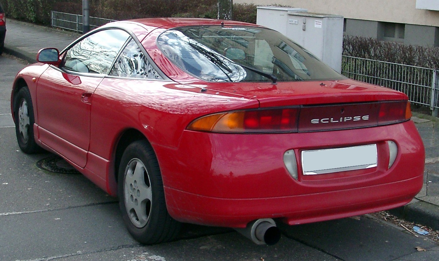 Red coupe rear view with taillights and single exhaust pipe.