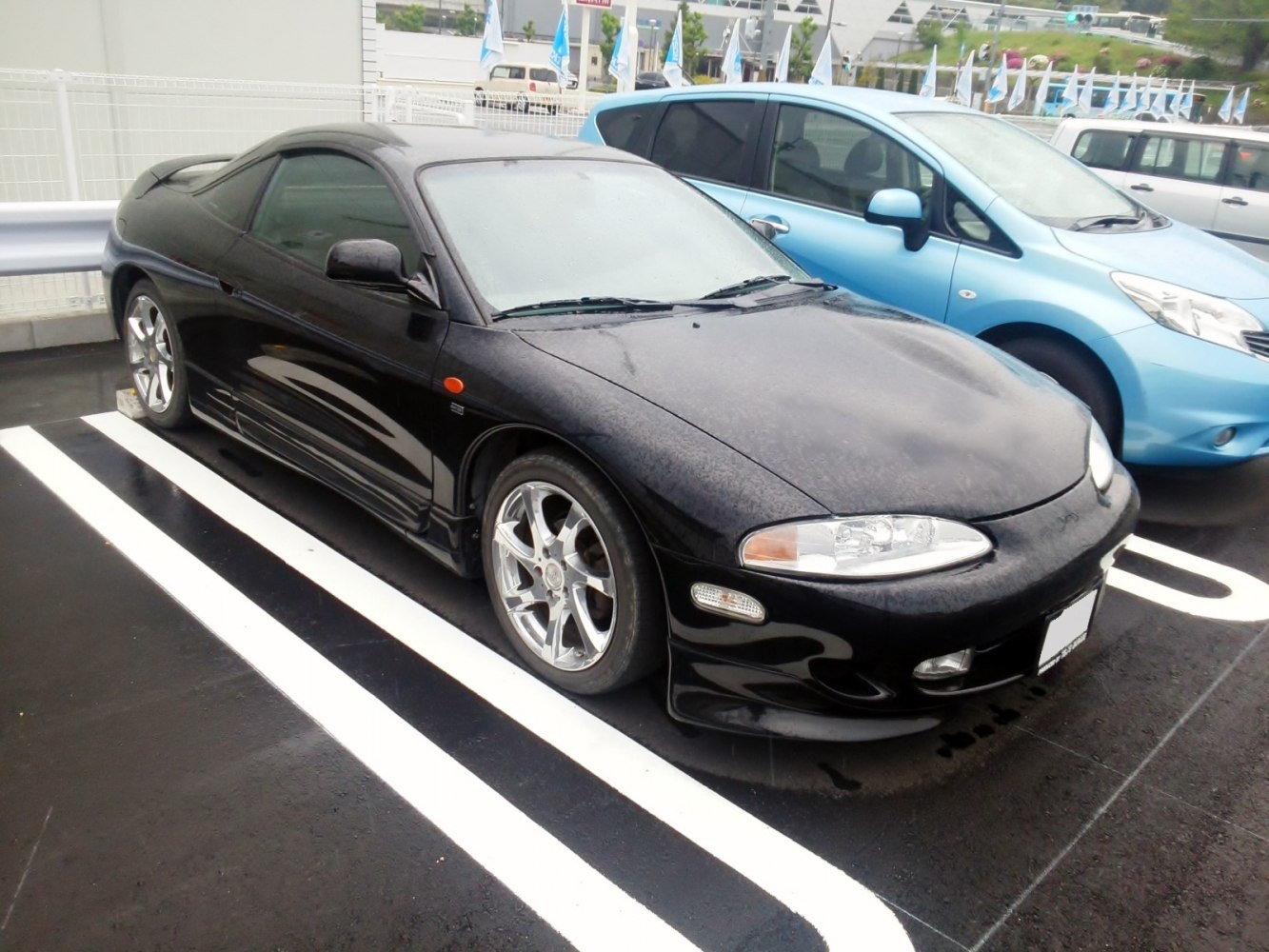 Sleek black sporty coupe with chrome wheels and aerodynamic design.