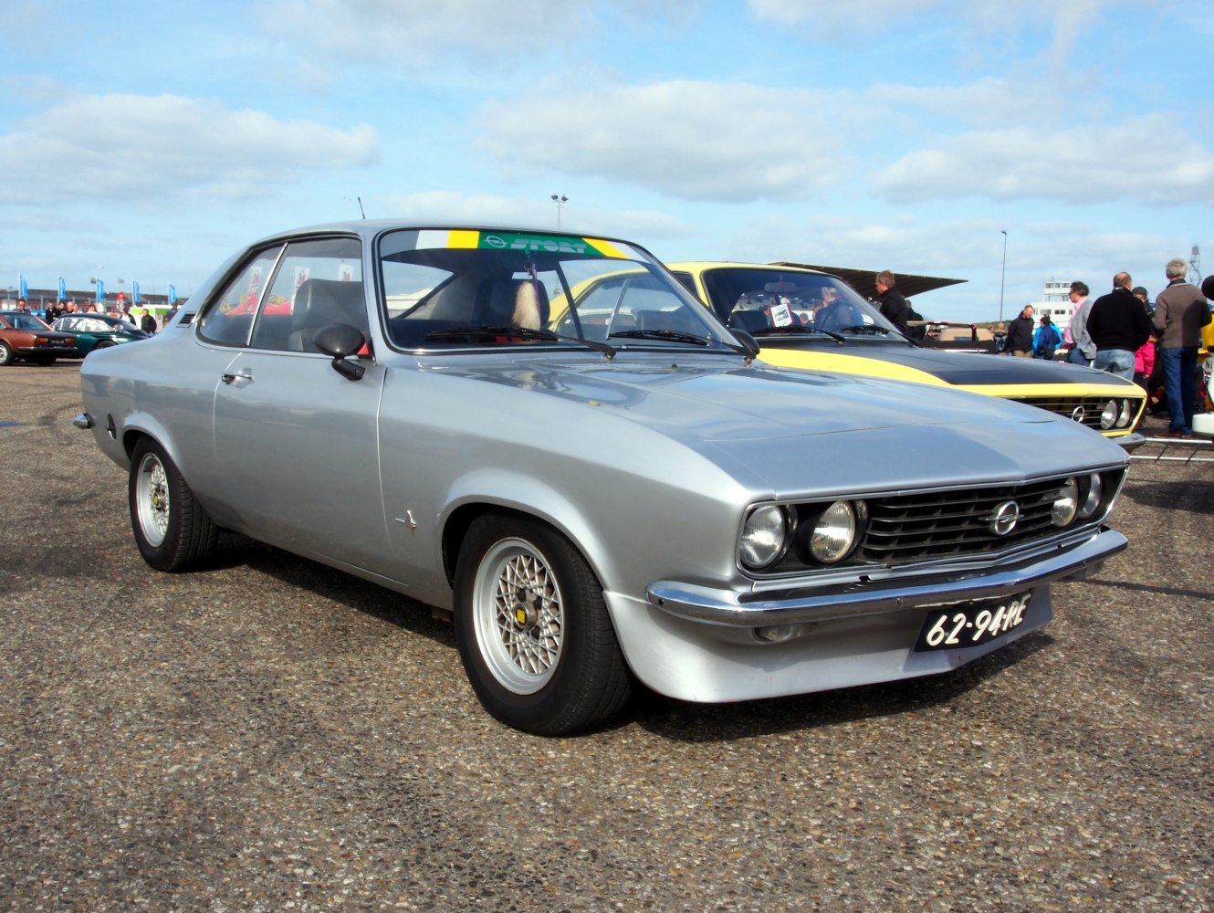 Silver vintage coupe with retro multi-spoke wheels and dual round headlights