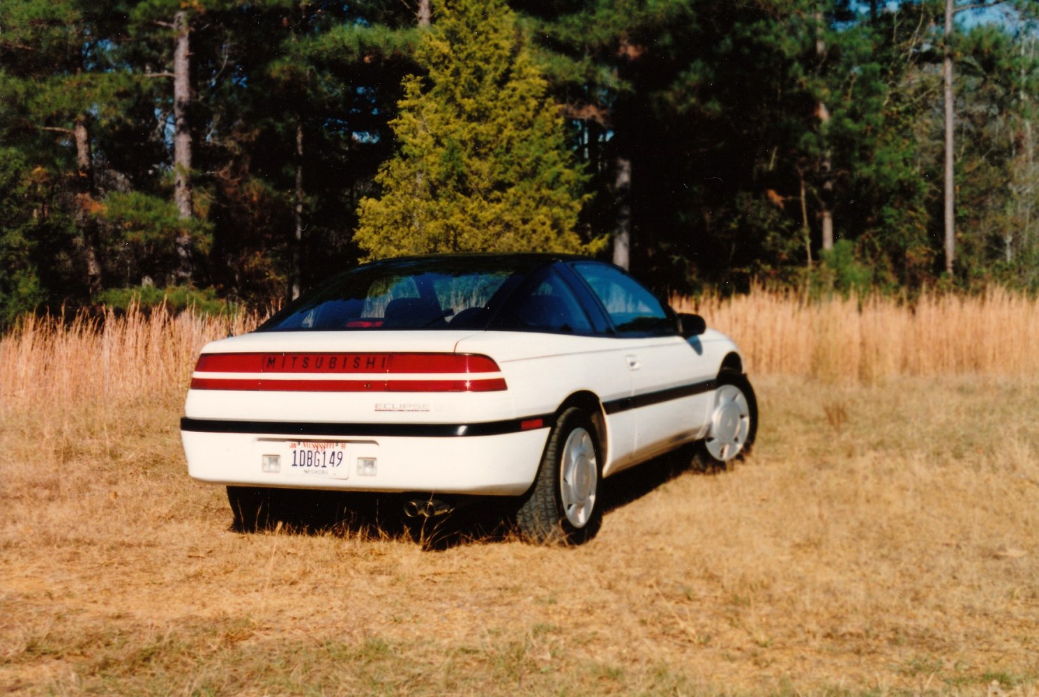 Rear view of a white hatchback with dual exhaust and wide taillight bar