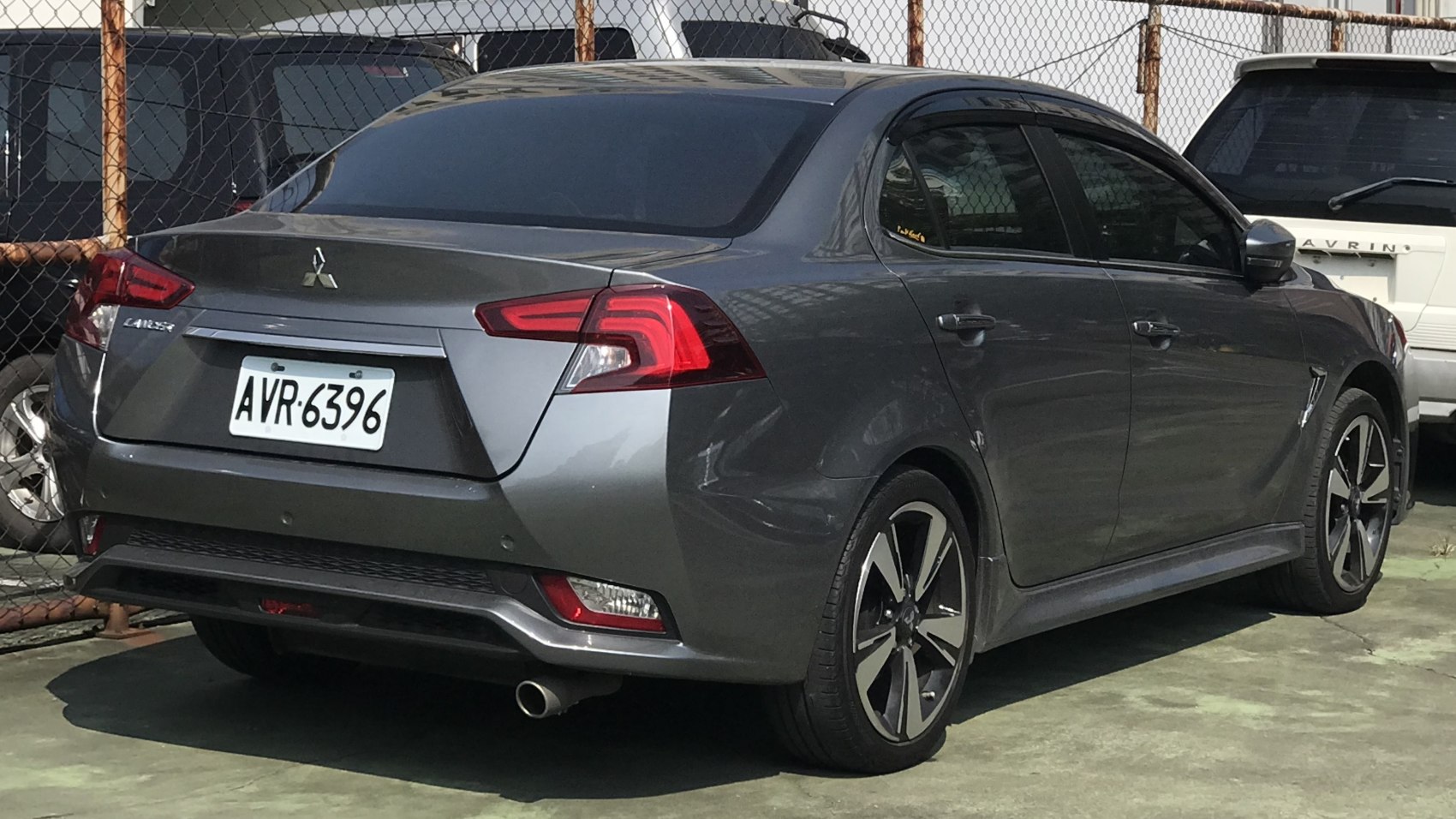 Rear view of sedan with unique taillights and sporty alloy wheels