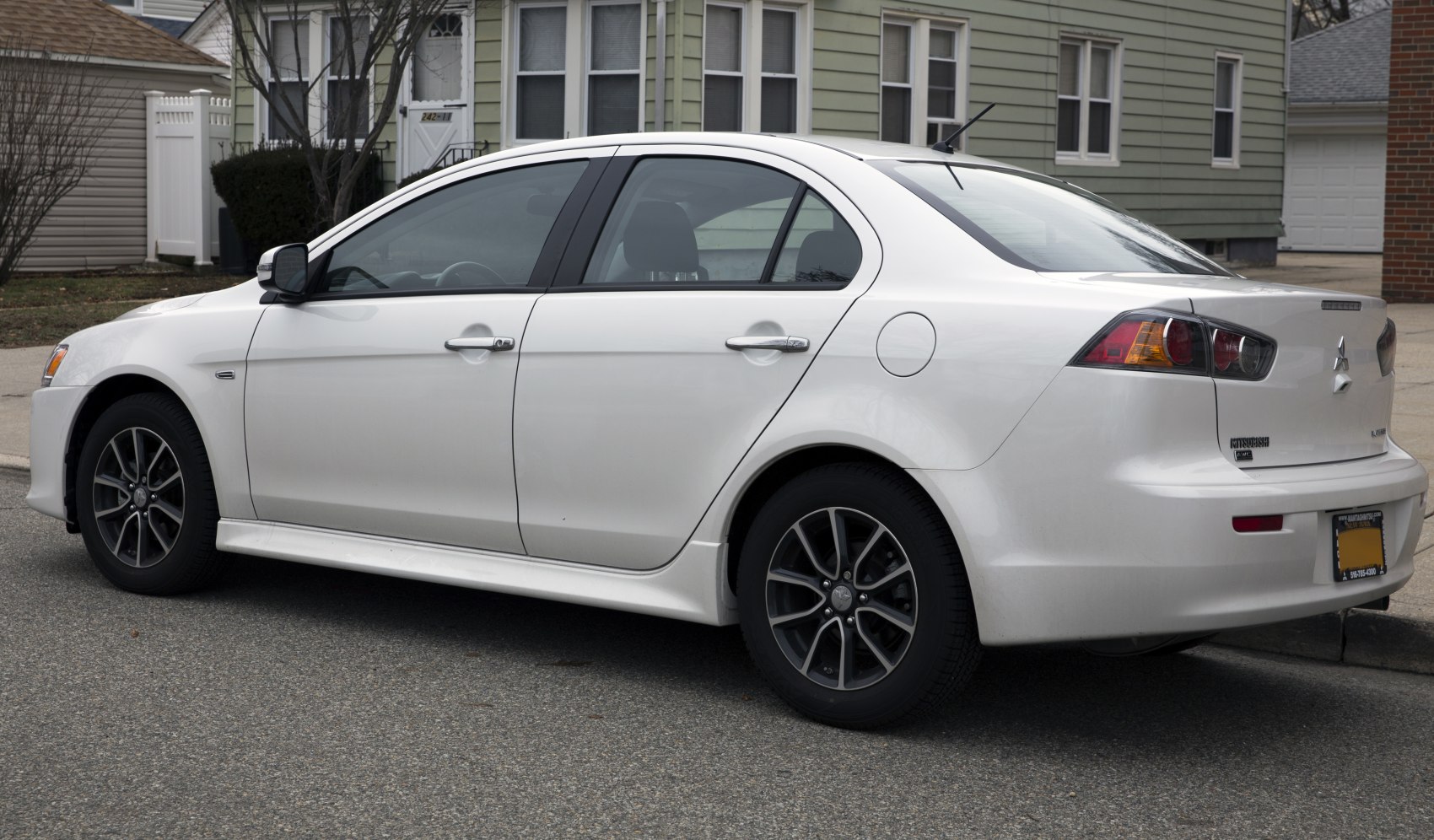 Side and rear views of a white sedan with alloy wheels and modern taillights