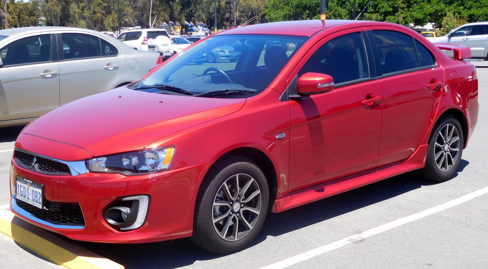 Sporty red sedan front-side view with alloy wheels