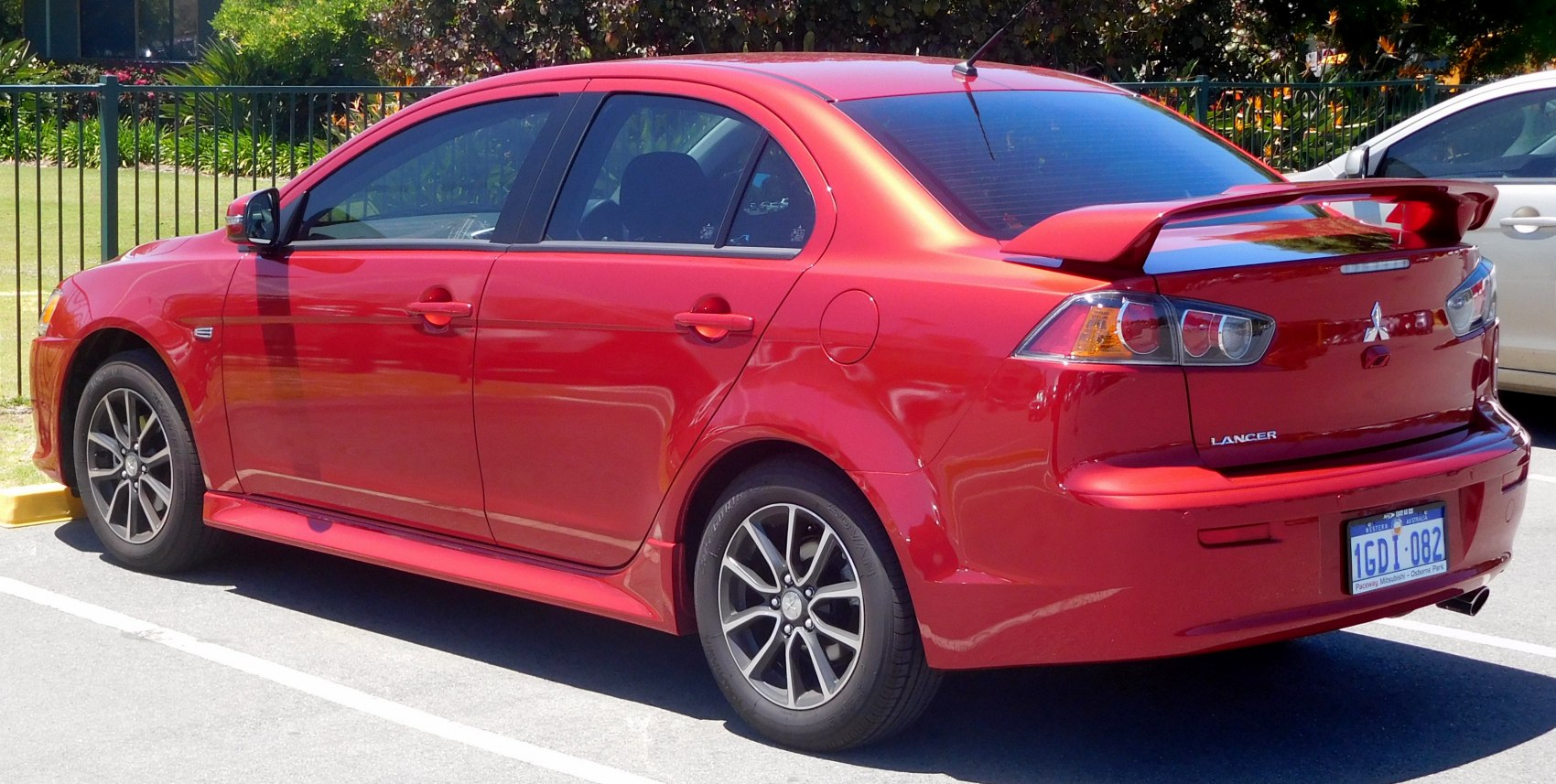 Red sedan with rear spoiler and alloy wheels