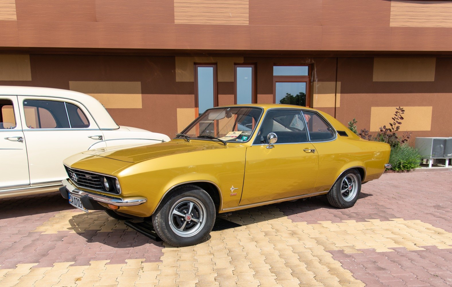 Yellow two-door coupe with retro wheels and chrome mirrors.