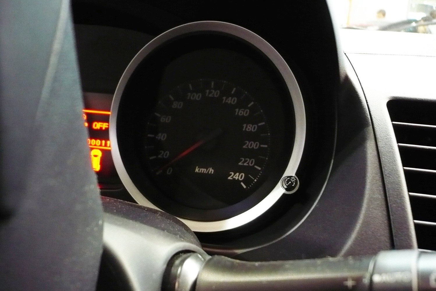 Close-up of a circular speedometer with km/h scale in car dashboard