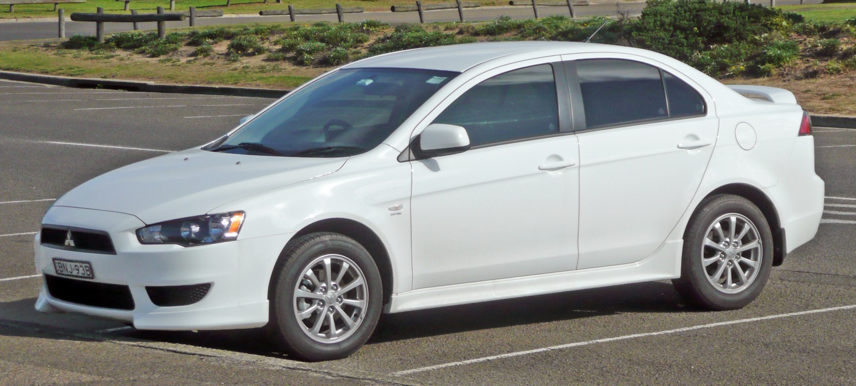 White sedan with alloy wheels and rear spoiler