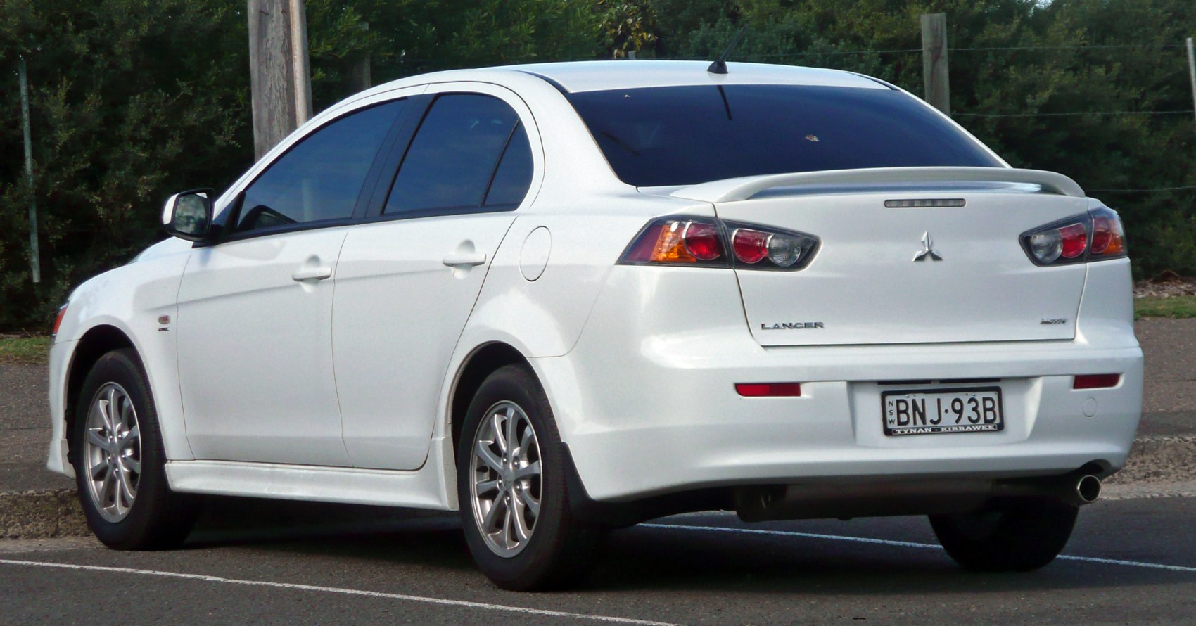 Rear view of a compact sedan with spoiler and alloy wheels