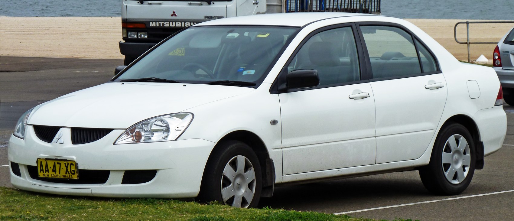 White sedan with sharp headlights and distinct wheel covers