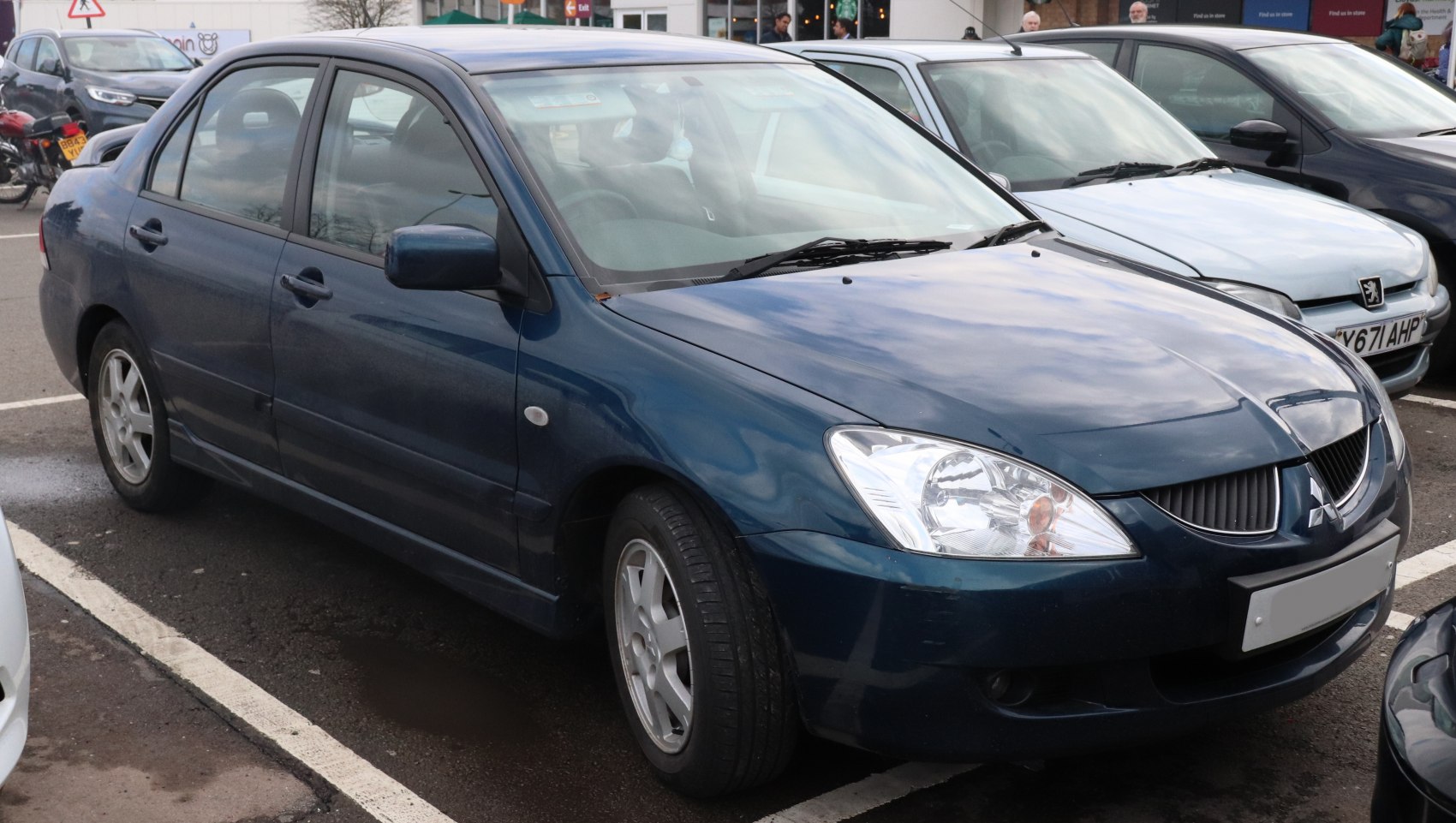 Blue compact sedan with clear headlights and alloy wheels side-front view