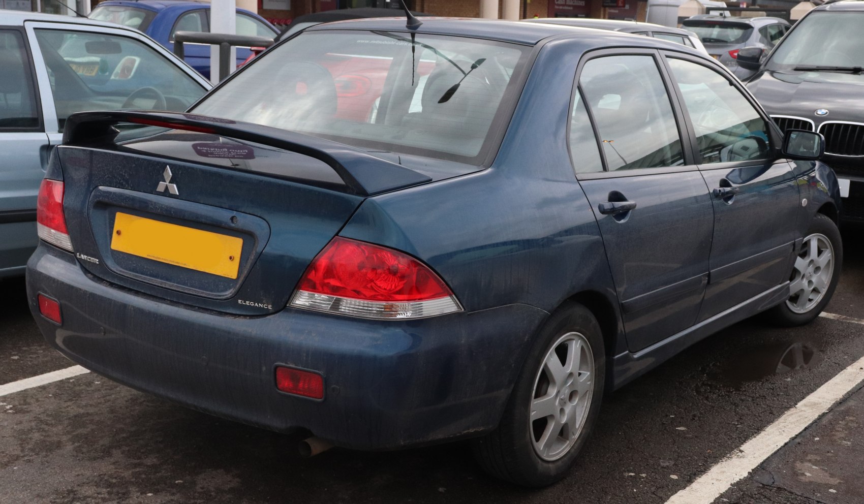 Rear side view of sedan with spoiler and alloy wheels