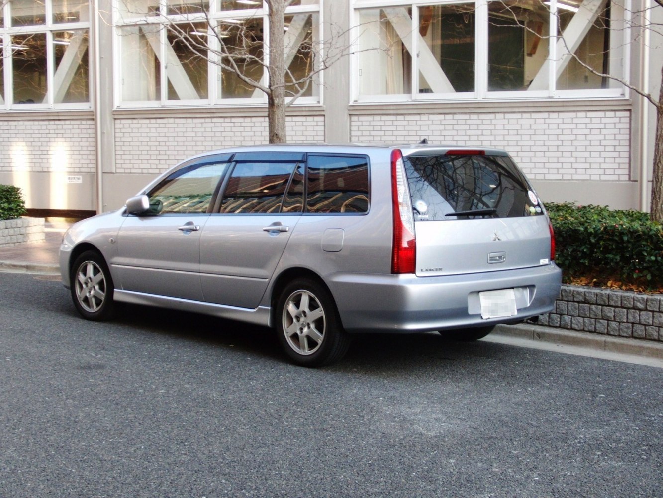 Silver compact wagon rear side showing tail lights and windows