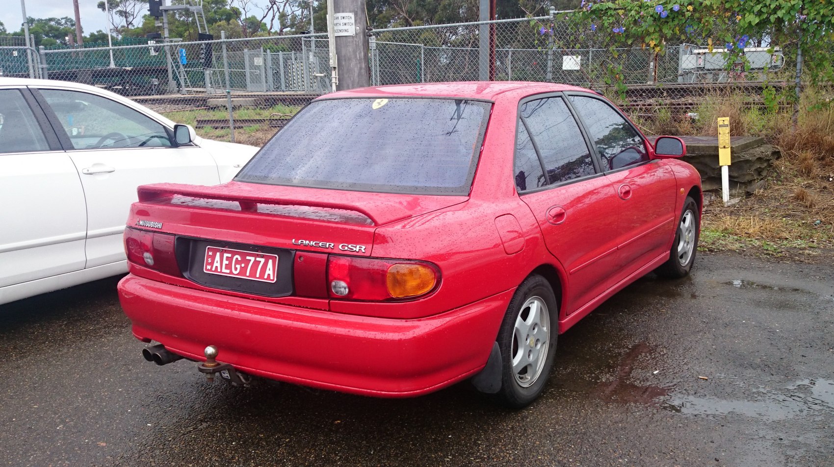 Rear view of red sedan with spoiler and dual exhaust