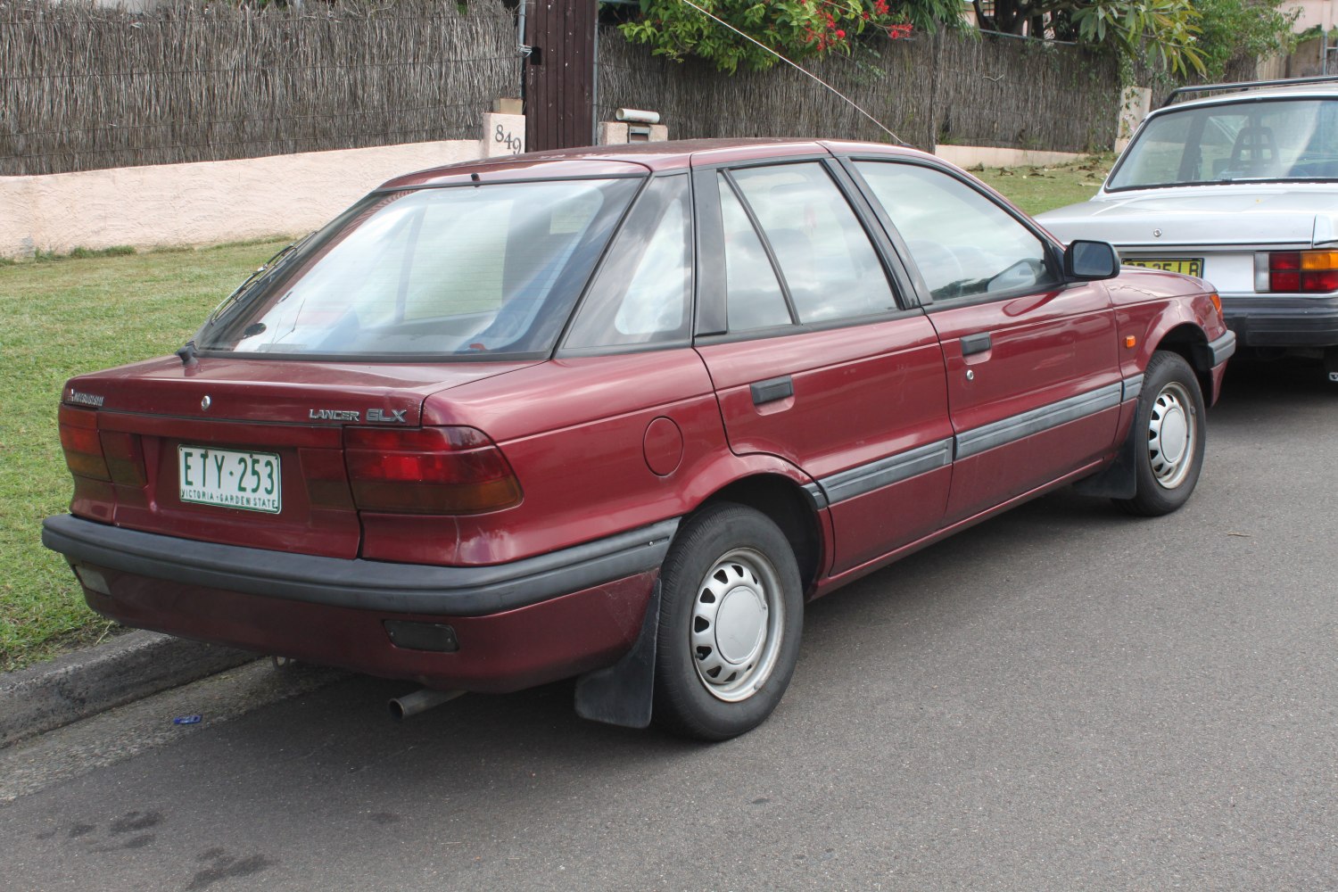 Rear-side view of a classic hatchback with rounded taillights and steel hubcaps.