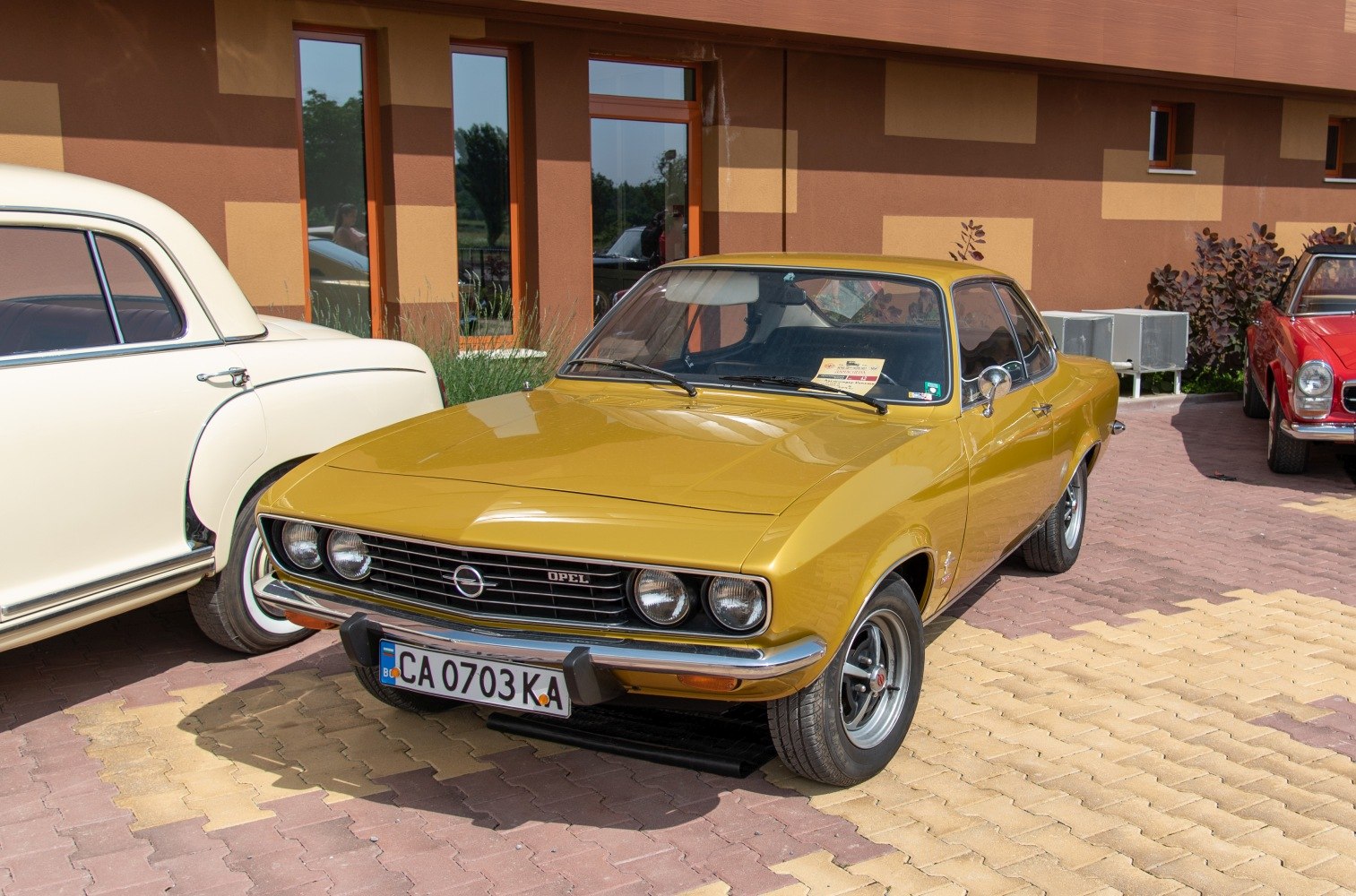 Yellow vintage coupe with distinct grille and round headlights