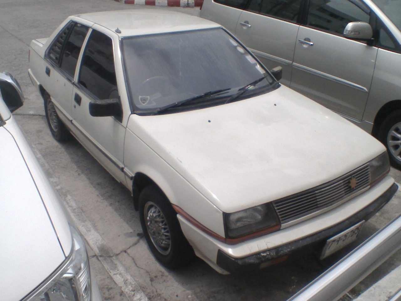 Vintage sedan with boxy design, wire-spoke wheels, and rectangular headlights