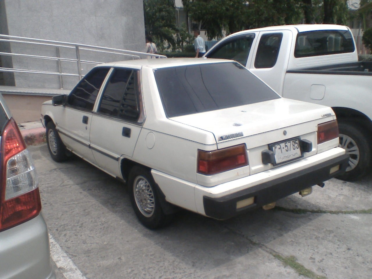 Classic white 4-door sedan rear with tinted windows and square tail lights.