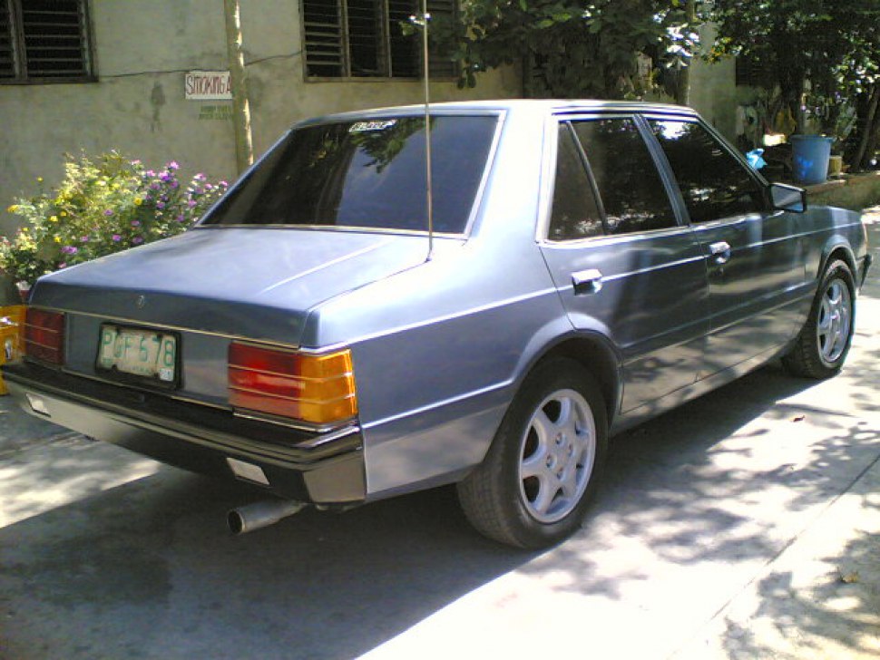 Rear view of a vintage 1980s sedan with angular tail lights and alloy wheels