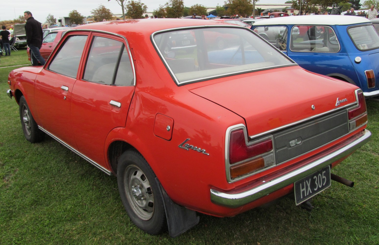 Vintage red sedan rear side with classic tail lights and boxy design