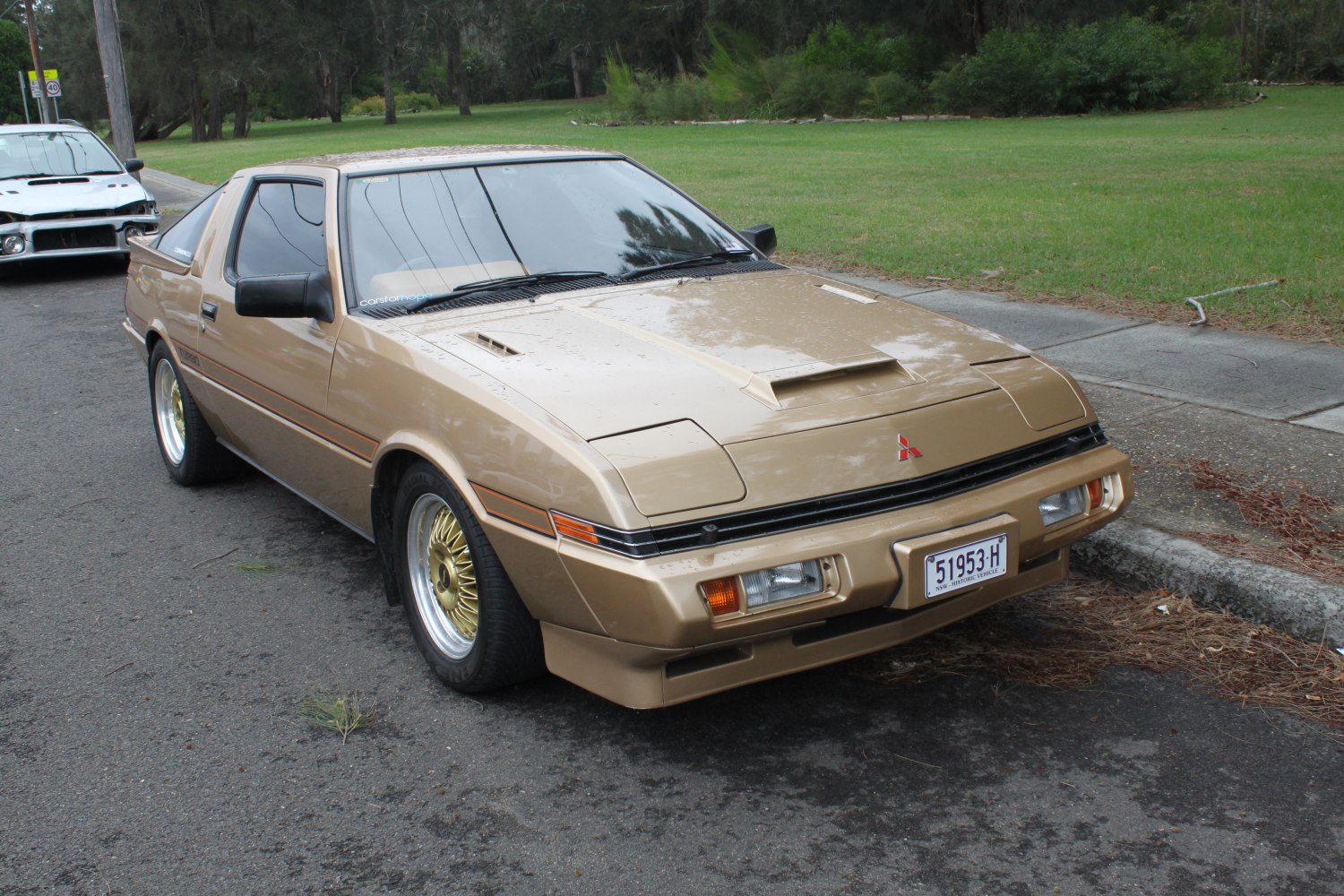 Classic sports coupe with hood scoop and pop-up headlights.