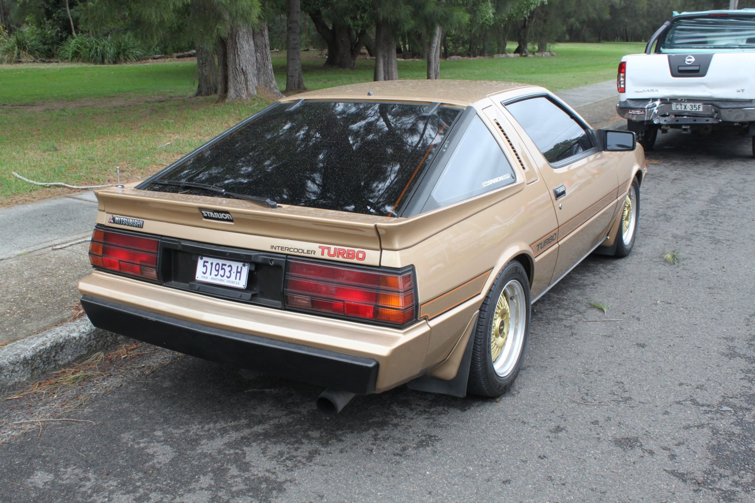Rear and side view of a vintage 1980s sports coupe with turbo badge