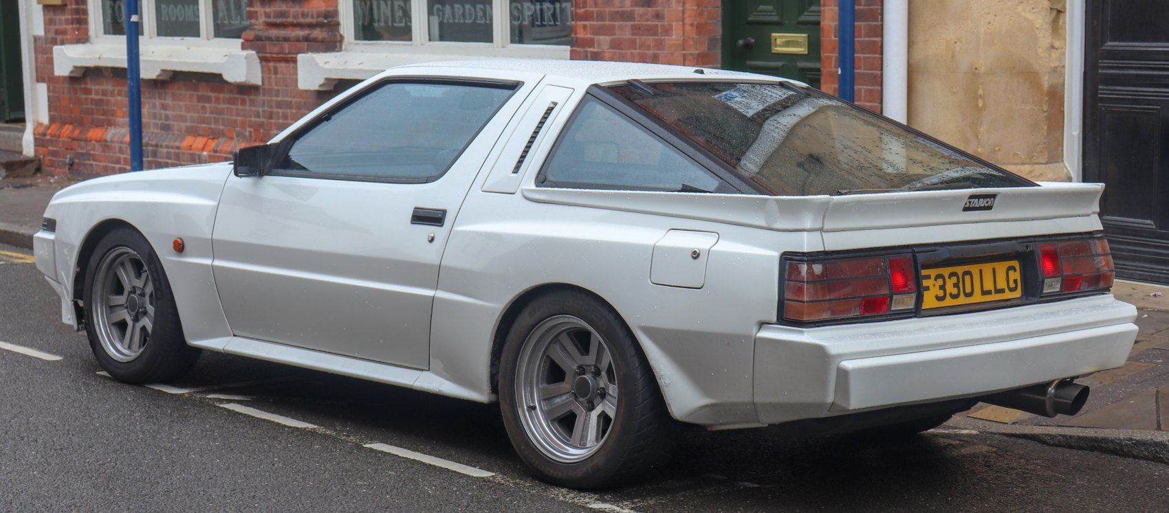 White sports coupe with rear spoiler and slot-style wheels