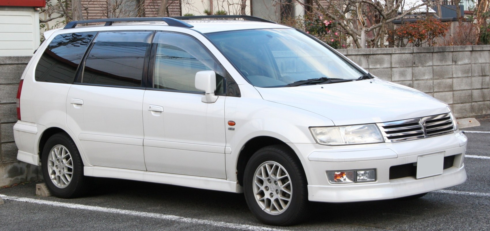 White mid-size station wagon with alloy wheels and roof rails