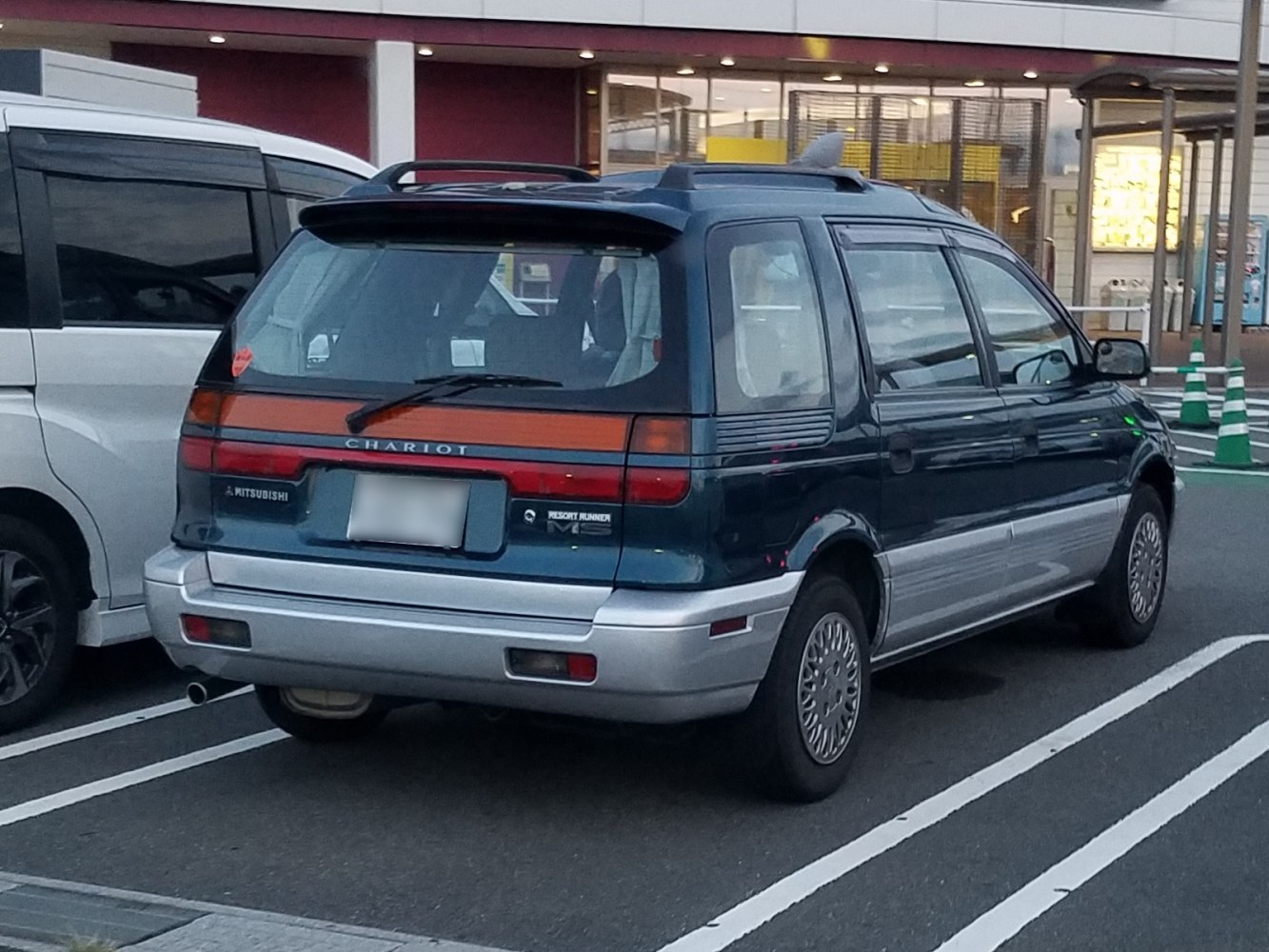 Rear view of a 1990s minivan with distinctive rear hatch and taillight setup