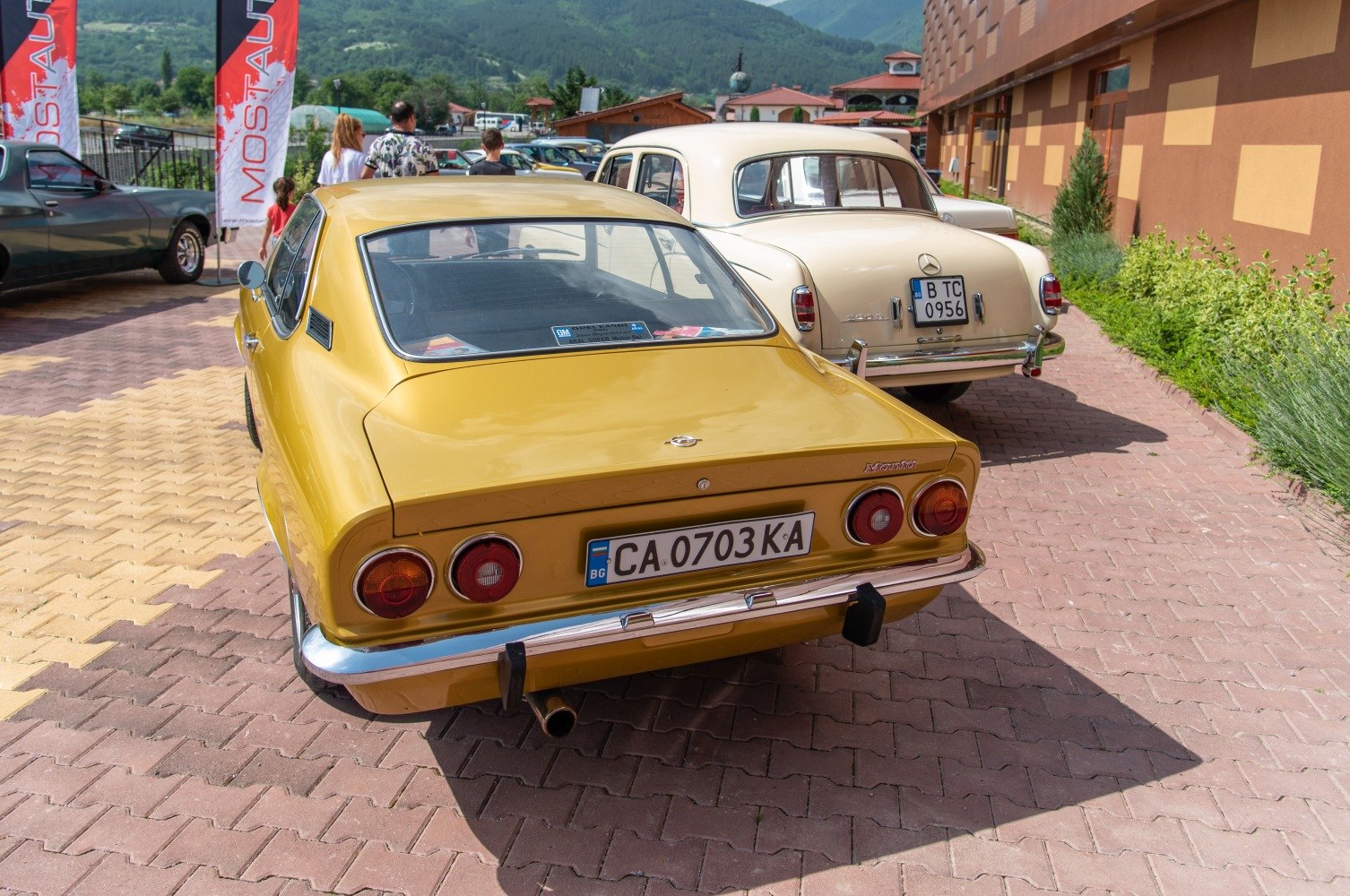 Bright yellow vintage coupe rear with round taillights and chrome bumper
