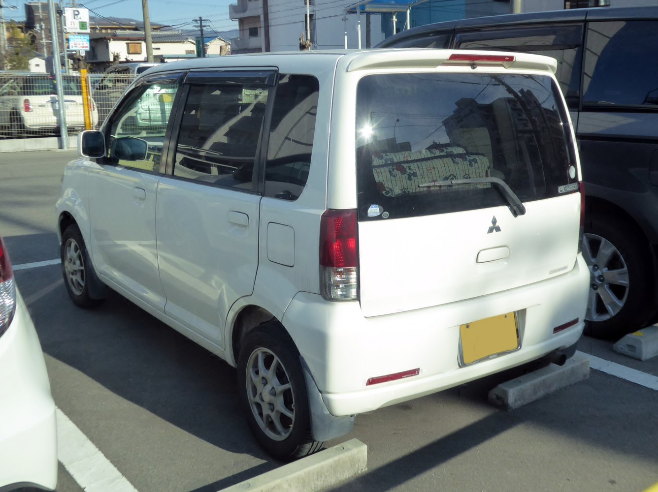 Compact white wagon with rear spoiler and alloy wheels
