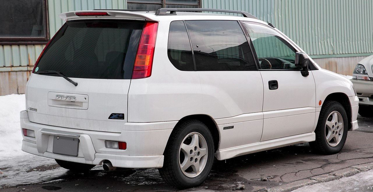 Rear and side view with tall vertical rear lights of a white compact SUV