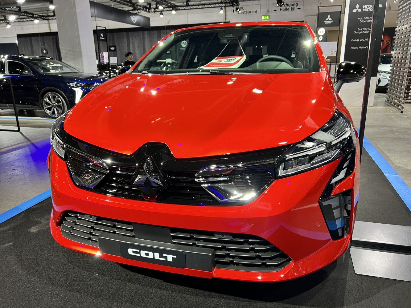 Bold red hatchback front view with sleek grille and LED headlights