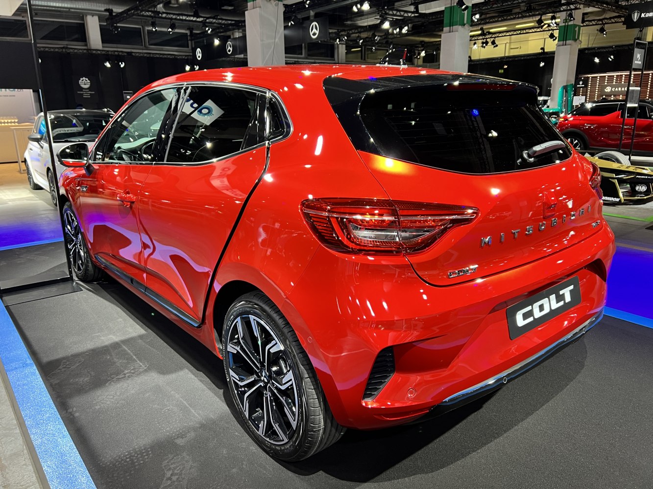 Rear and side profile of a modern red hatchback with sleek design and alloy wheels